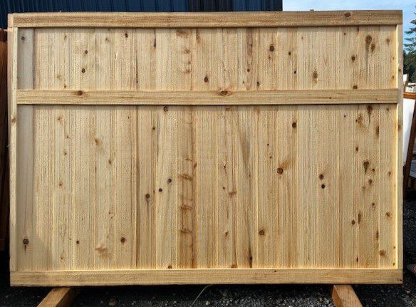 A wooden fence panel with vertical planks and a horizontal support beam.